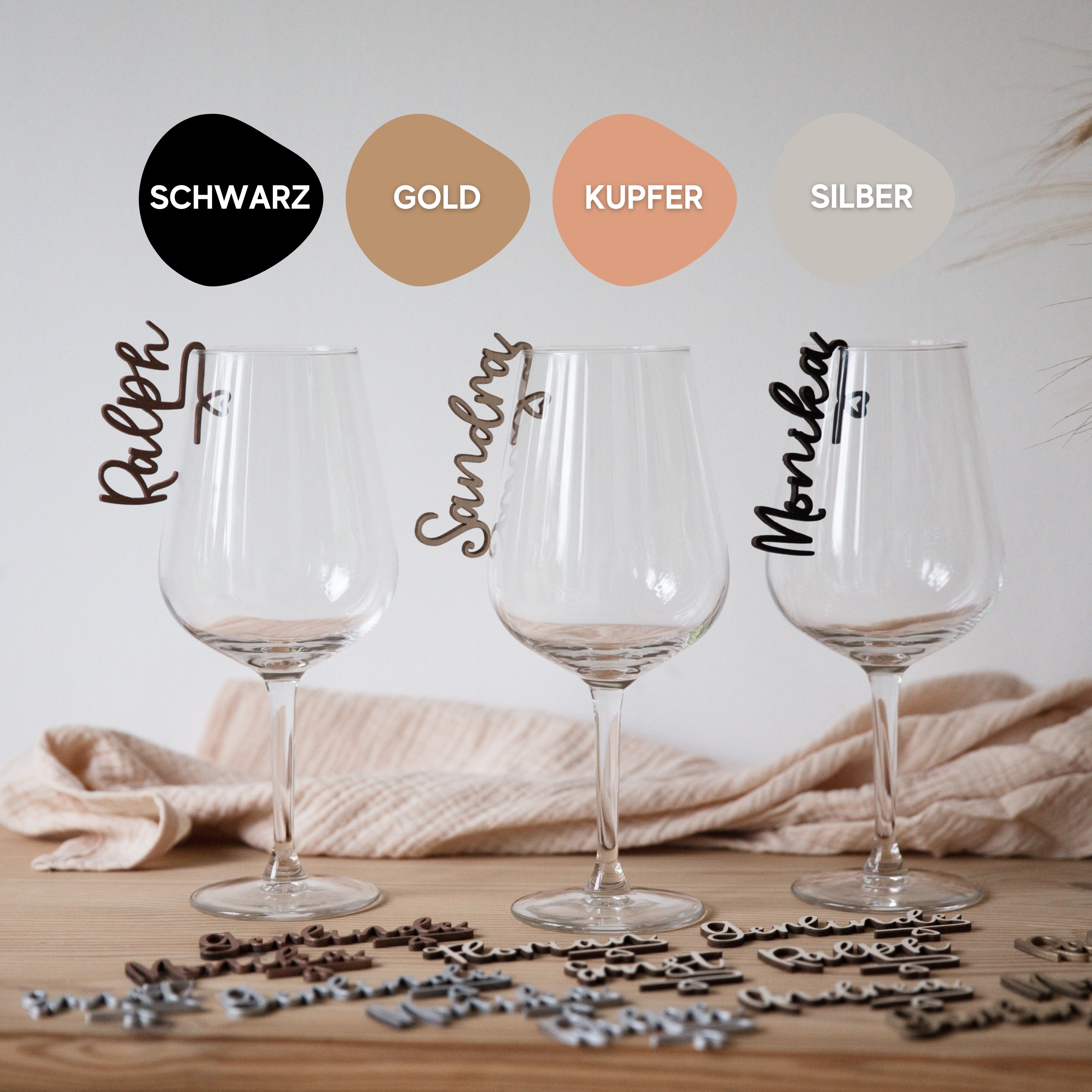 Drei Weingläser mit laserhelden Glasmarkierer mit Namen; Farboptionen: Schwarz, Gold, Kupfer und Silber.
