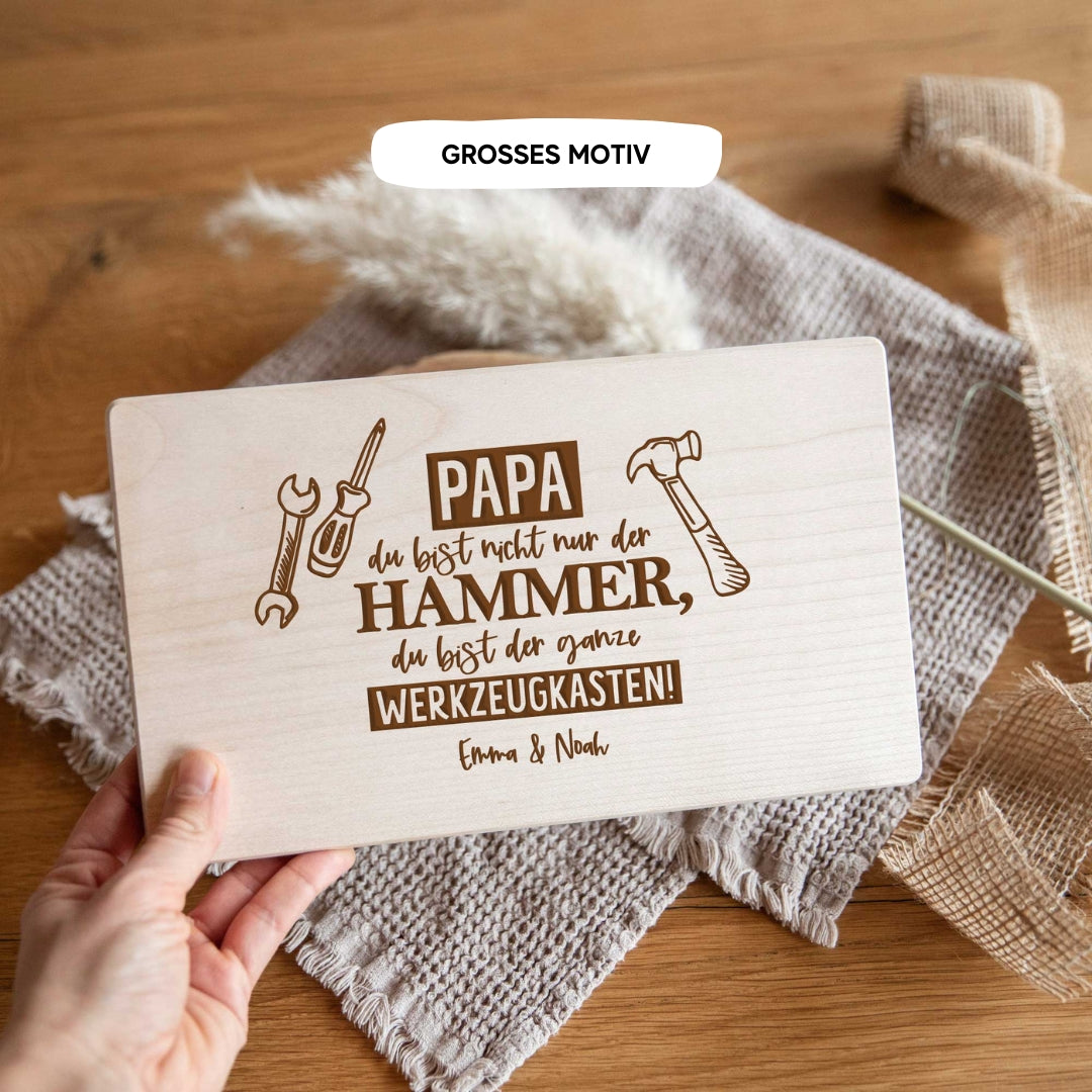 Jemand hält ein laserhelden personalisiertes Brotzeitbrett mit Gravur – Geschenk zum Vatertag für Papa auf einem rustikalen Tisch – perfekt als individuelles Präsent.
