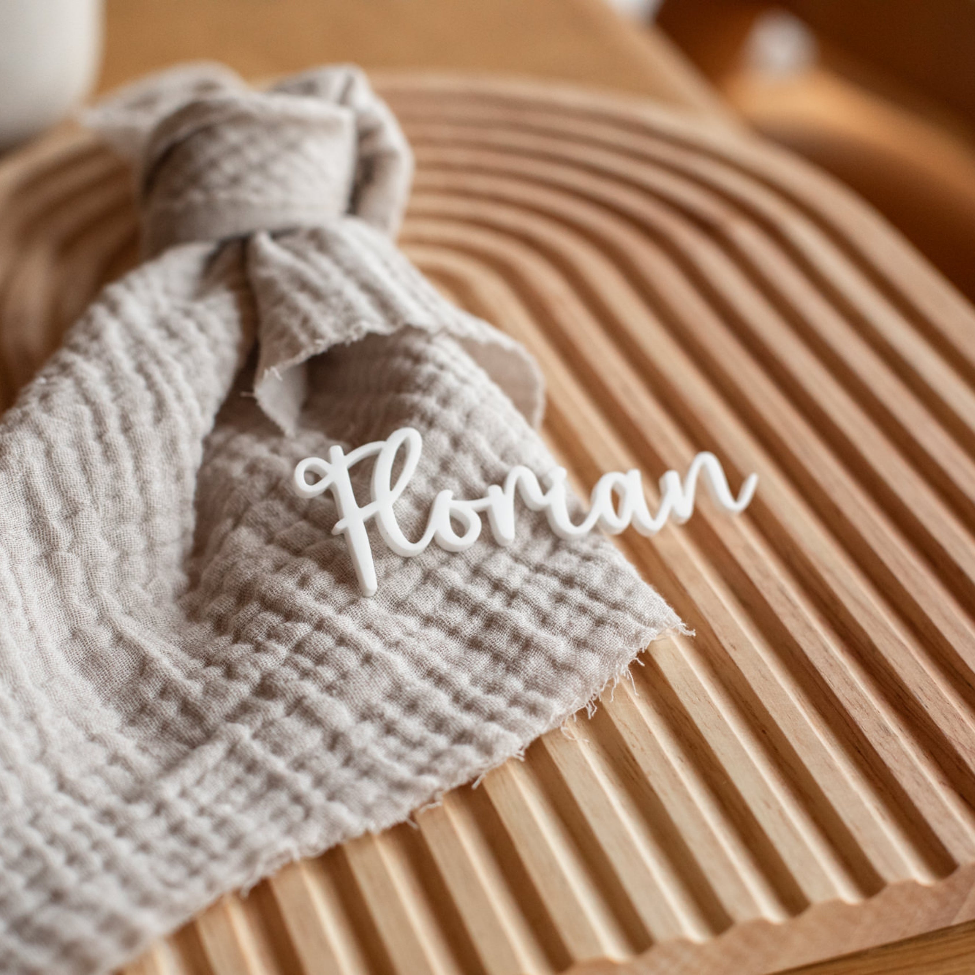 Die Namensschilder „Hochzeit“ von Laserhelden bestehen aus strukturiertem Stoff und einem ausgeschnittenen Blumennamen auf einer Holzoberfläche mit Wellenmuster und verleihen Ihrer Einrichtung eine atemberaubende, einzigartige Note.