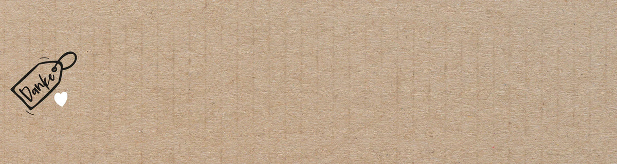 Brauner, strukturierter Papierhintergrund mit einem kleinen „Enjoy“-Anhänger und einem weißen Herz in der oberen linken Ecke.